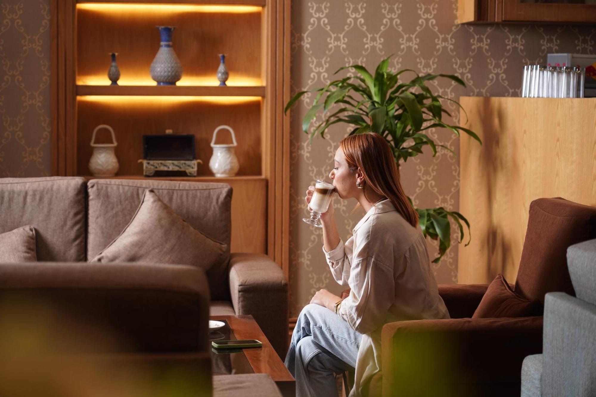 Thousand Nights Hotel Amman Bagian luar foto A woman drinking coffee